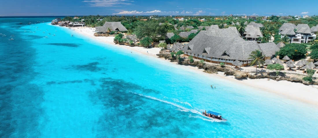 Zanzibar adasında turkuaz sular, beyaz kumlar ve palmiye gölgeleriyle tropik manzara